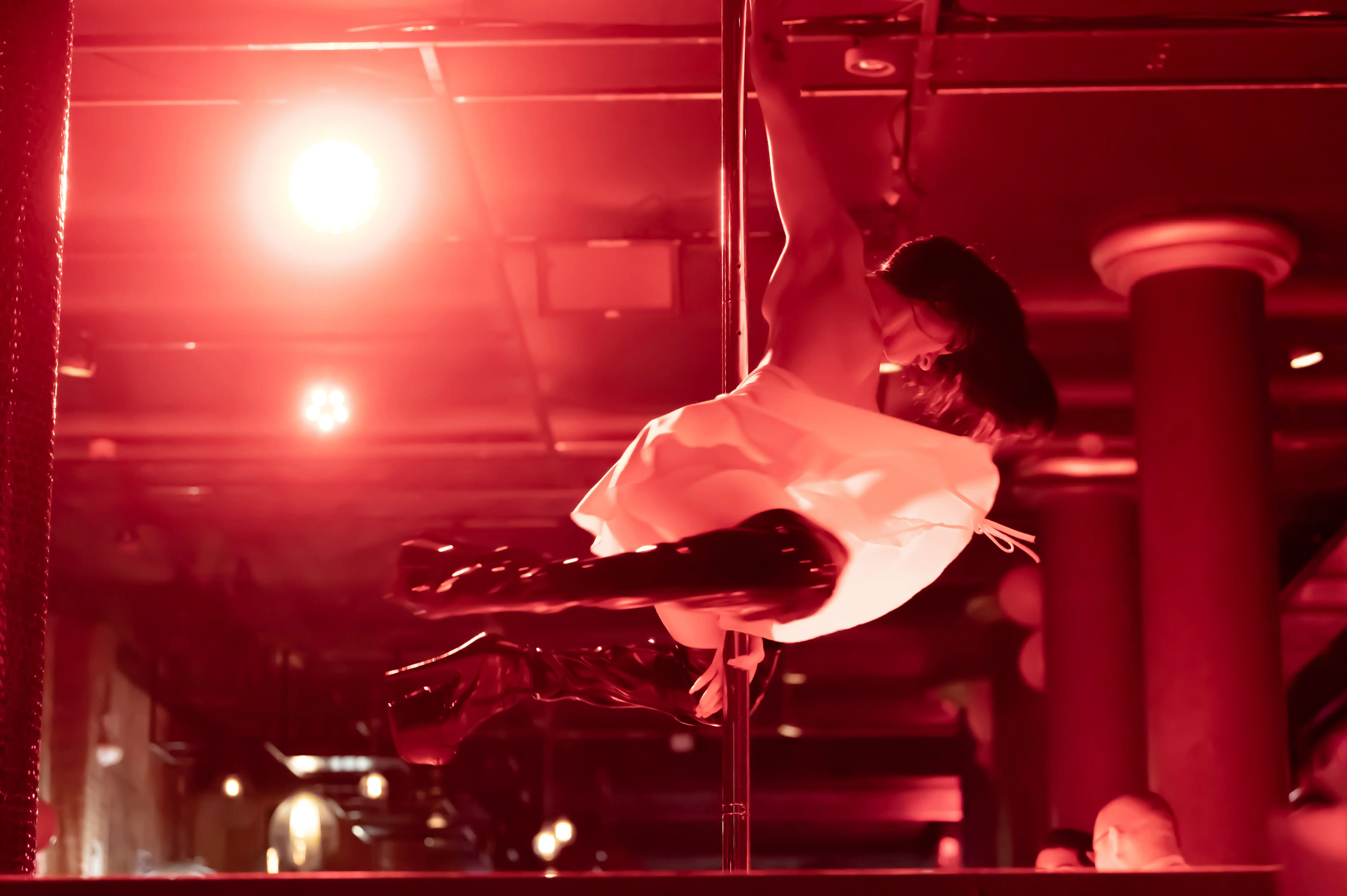 Spettacolo di pole dance in un Bordelli a Barcellona con luci rosse intense